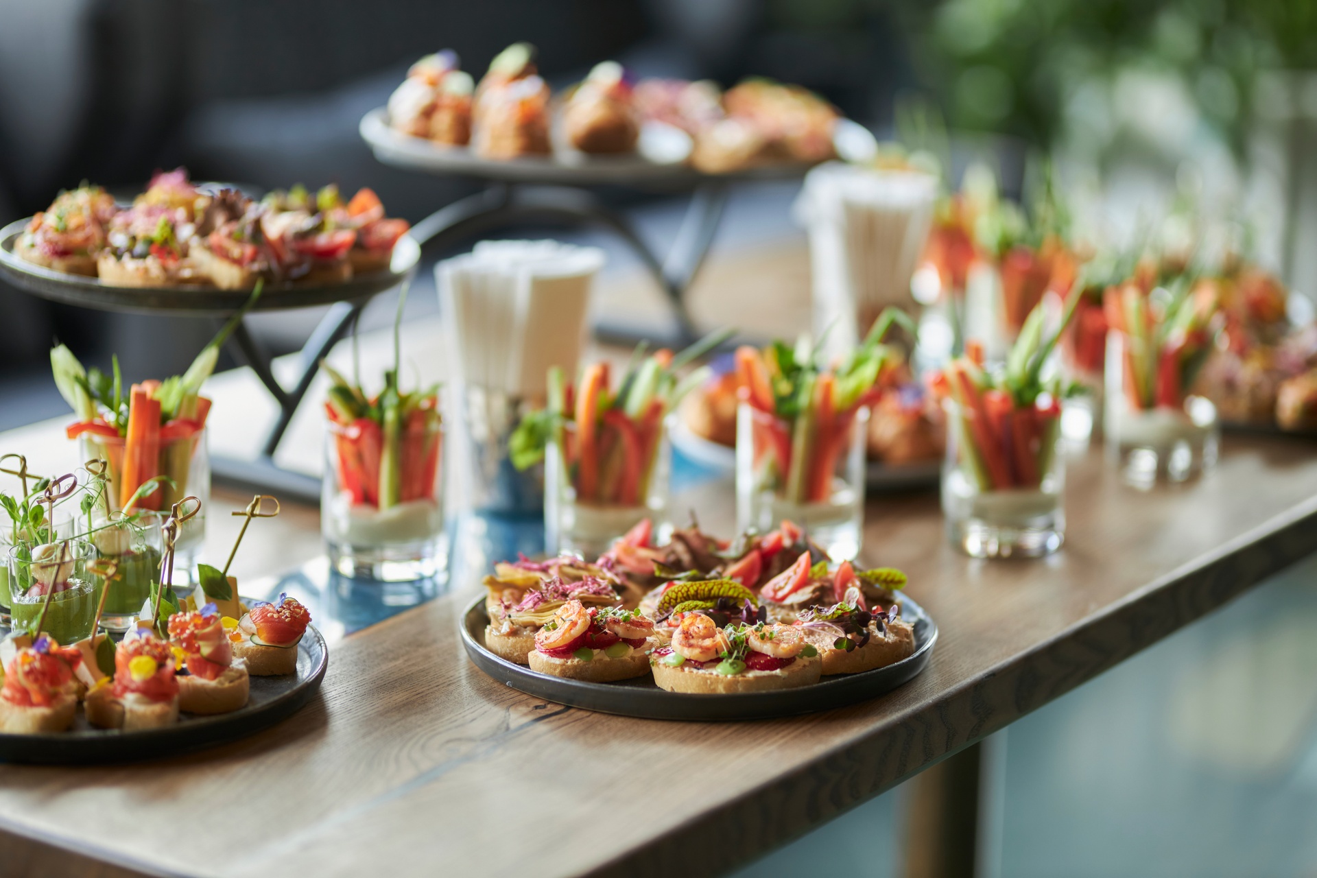 Lots of good food on the table. Small sandwiches on a black plat